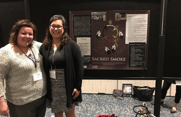 Two women presenting the Sacred Smoke project